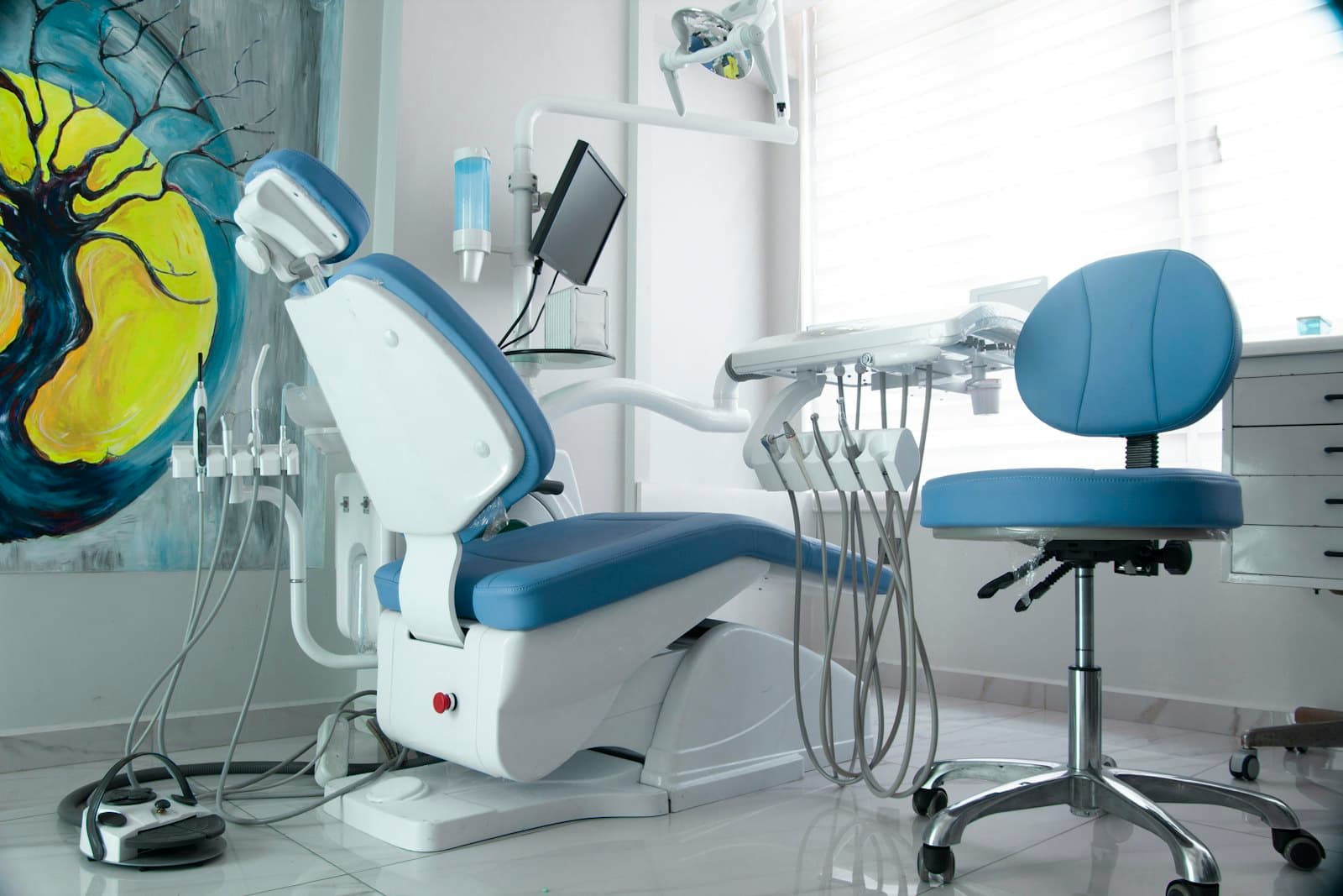 Modern dental clinic interior with treatment chair, equipment and a feature wall mural