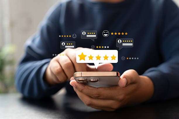 Patient leaving a five-star review on a smartphone with rating bubbles floating above the screen
